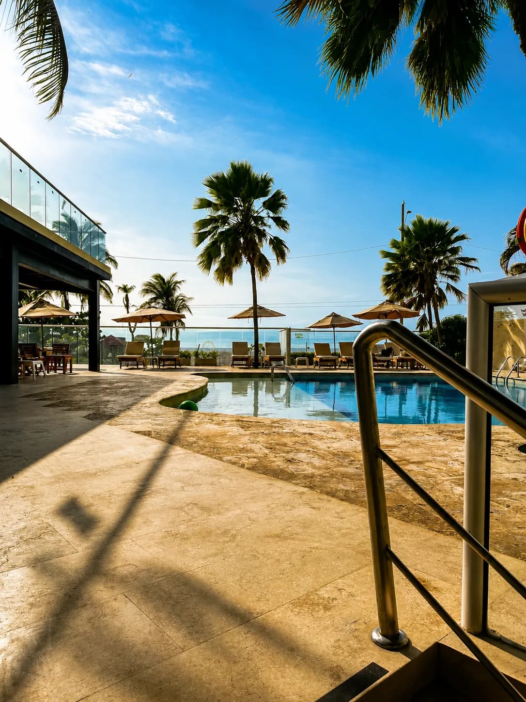 Piscina del Hotel Playa Club entre palmeras, con el mar Caribe al fondo en Bocagrande, Cartagena